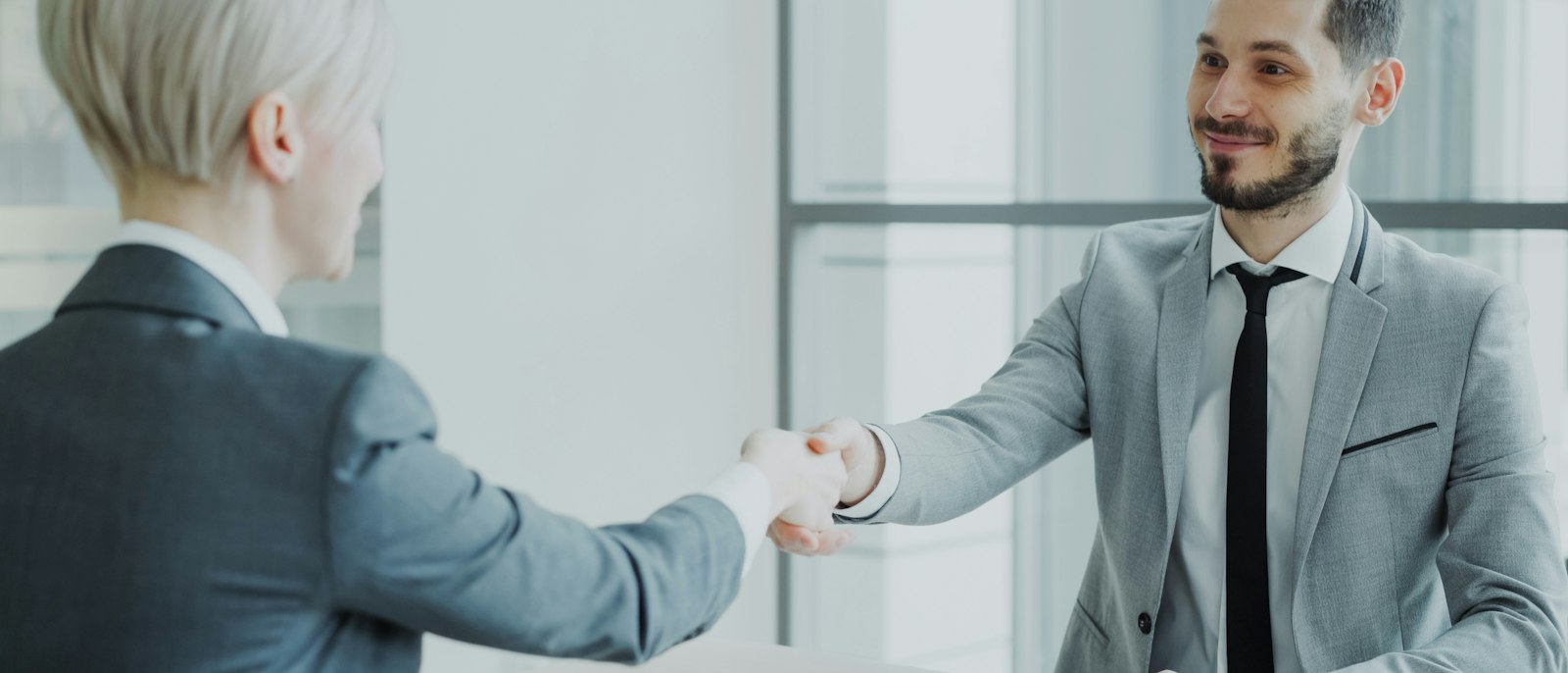 Two professionals shaking hands across a table